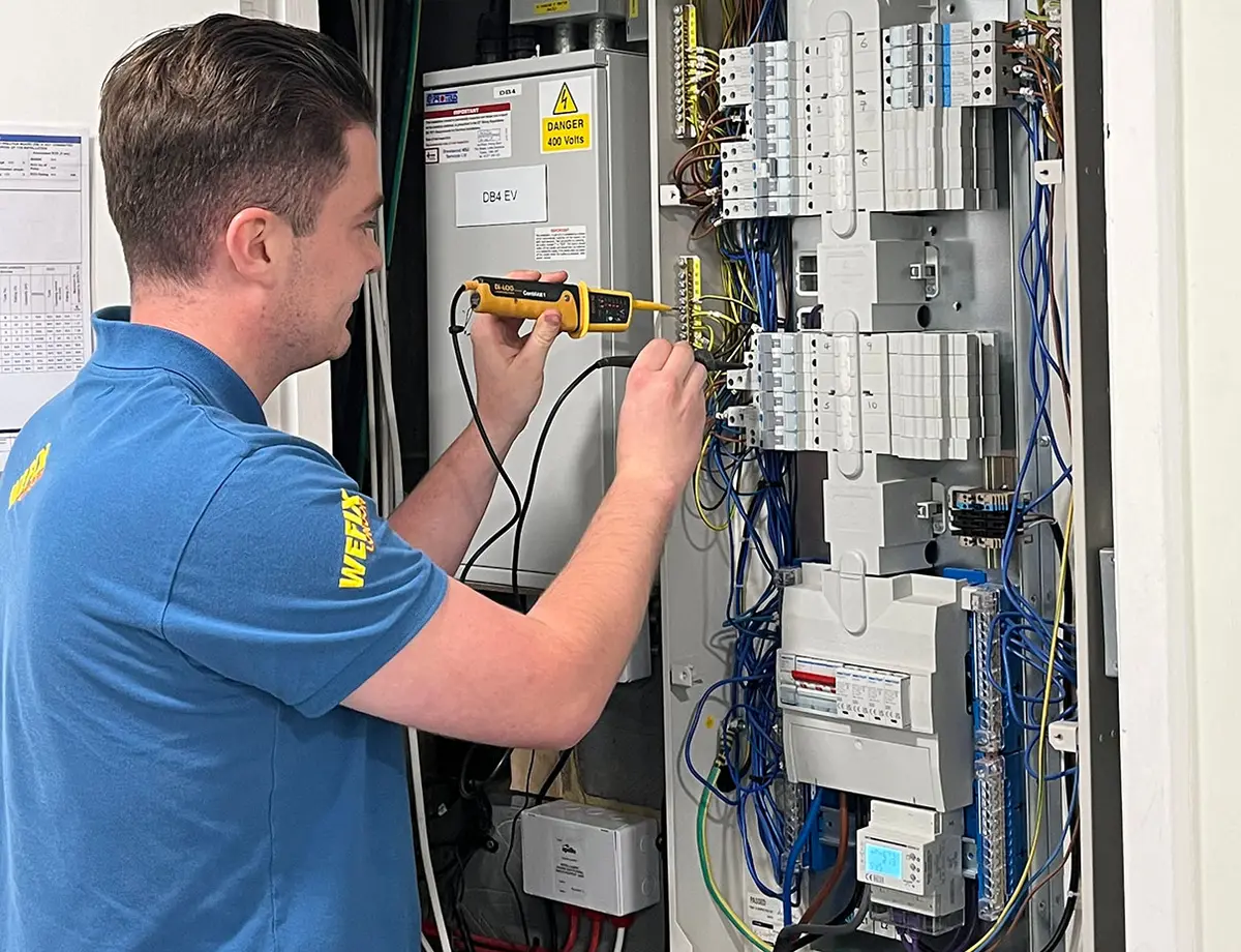 Electrician installing wiring in a London property