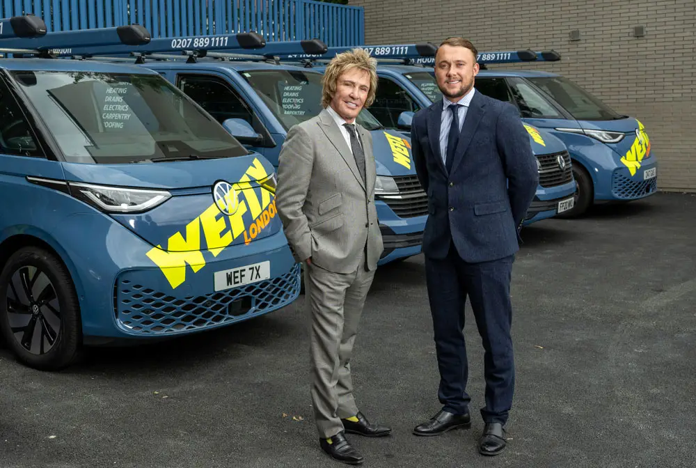 Charlie Mullins OBE and Scott Mullins standing in front of a row of WeFix vans