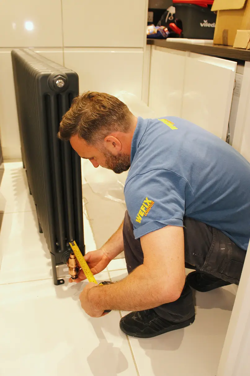 Engineer repairing a column radiator valve
